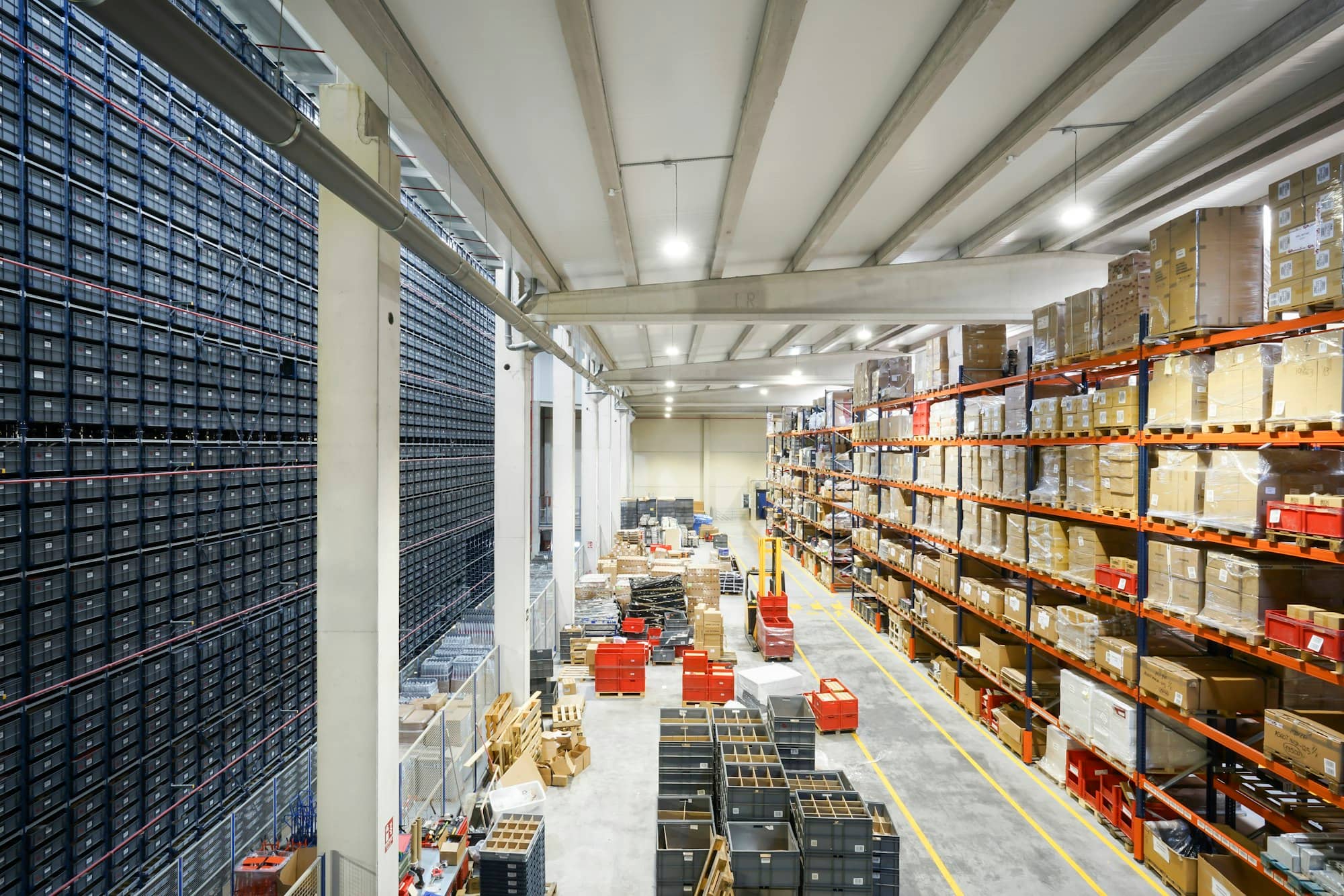 A long, bright warehouse aisle lined with shelves of goods
